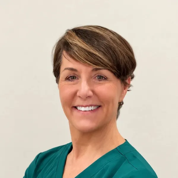 Dr. Chrysa Dunser smiling in teal Healing Haven Animal Clinic scrubs